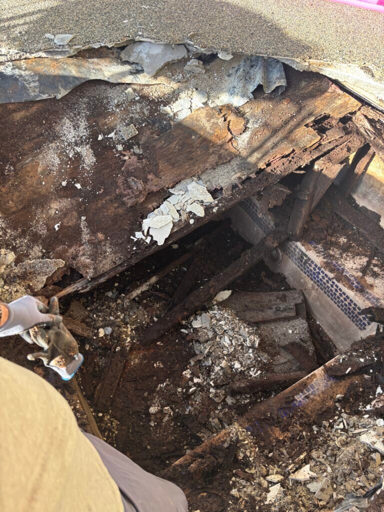 Damaged wooden roof structure and debris.