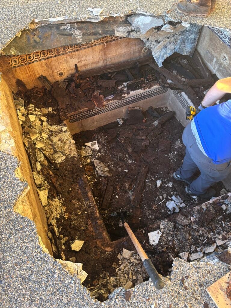 Workers repairing deep rot damage hole